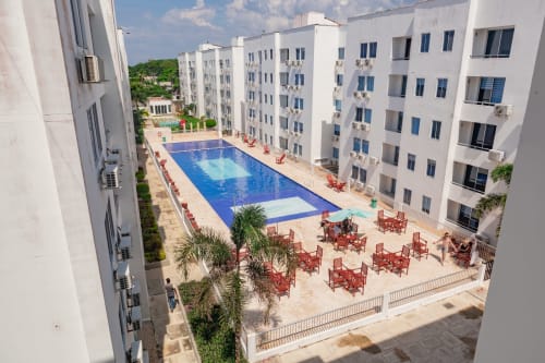 Vista aérea de la piscina azul de Olamar Living rodeada de edificios blancos en Santiago de Tolú