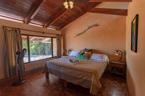 Tortuga room at Villa Mango B&B in Nosara with sea view, wooden ceiling, and terracotta floors