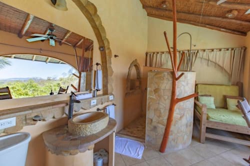 Congo room at Villa Mango B&B in Nosara with garden view, featuring open-air bathroom with stone sinks and wooden accents