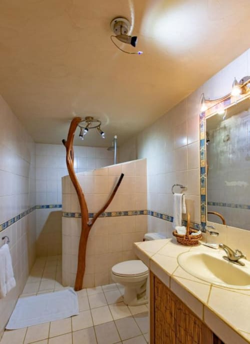 Iguana room bathroom at Villa Mango B&B in Nosara with tiled shower, sink, and natural wood accents