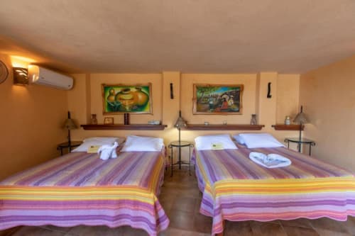 Iguana room at Villa Mango B&B in Nosara with twin beds, colorful striped bedding, and garden views
