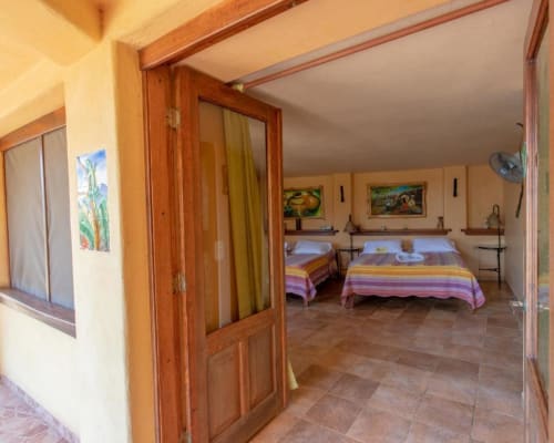 Iguana room at Villa Mango B&B in Nosara featuring twin beds, colorful bedding, and garden views
