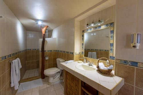 Luxurious bathroom in Iguana room at Villa Mango B&B, Nosara with dual vanity, large mirror, and garden view