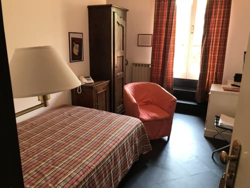Einzelzimmer Superior Hotel Beau Rivage in Alassio mit gestreiftem Bett, rotem Sessel, dunklem Holzschrank und Gartenblick