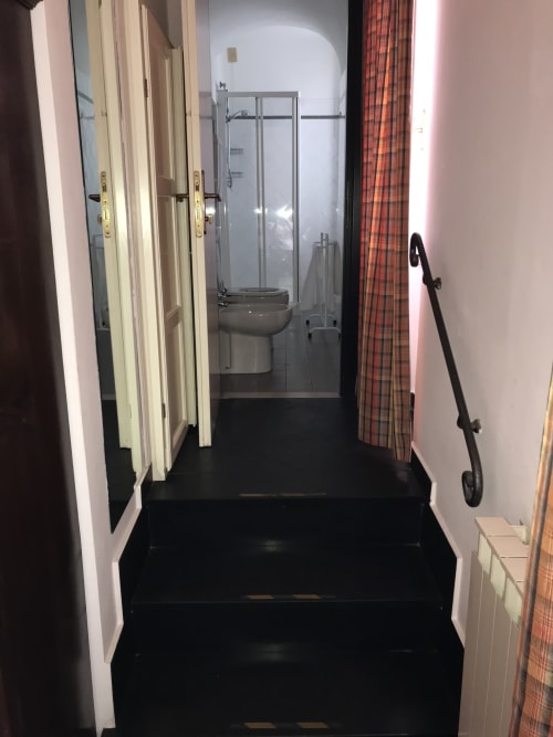 Schmaler Badezimmerflur im Hotel Beau Rivage Alassio mit sichtbarer Duschkabine und Toilette