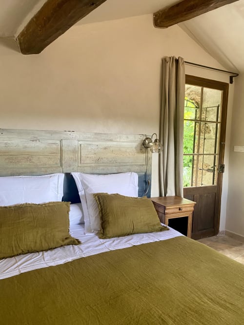 Rustikales Schlafzimmer in La Bouscatière mit sichtbaren Balken, geweißtem Kopfteil und Gartenblick in Moustiers-Sainte-Marie