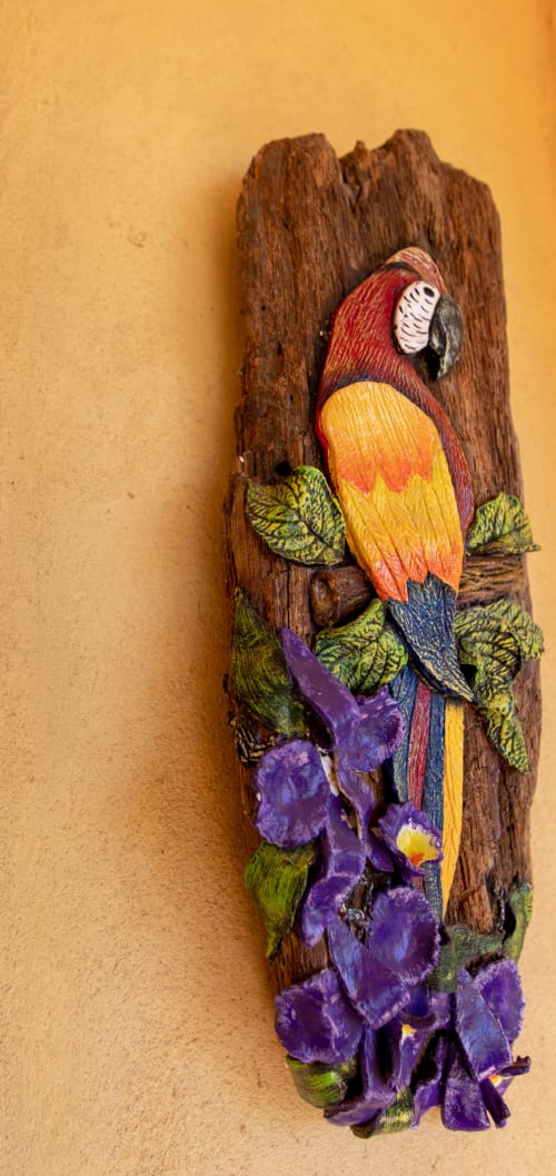 Colorful hand-painted macaw and purple flowers on driftwood at Villa Mango B&B garden room in Nosara, Costa Rica
