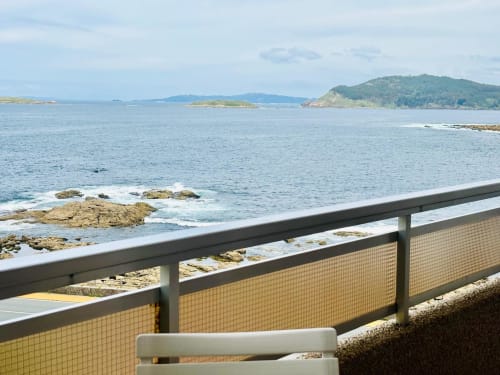 Terraza de apartamento en Baiona con vistas a las Islas Cíes, costa rocosa y península boscosa en Galicia, España