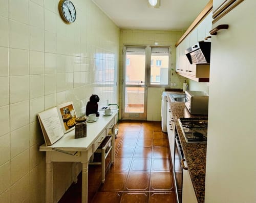 Moderna cocina pasillo en apartamento de Baiona con vistas al mar, con estufa de gas, fregadero y electrodomésticos