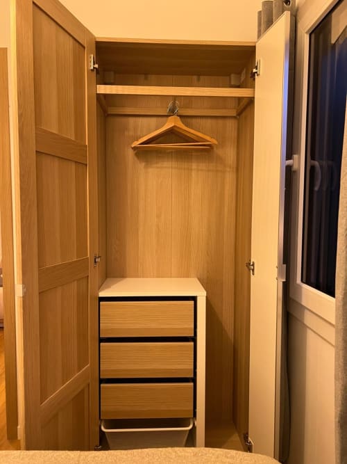 Armoire en bois ouvert avec portant et commode trois tiroirs dans chambre lumineuse, Camping La Lézardière, La Valette du Var
