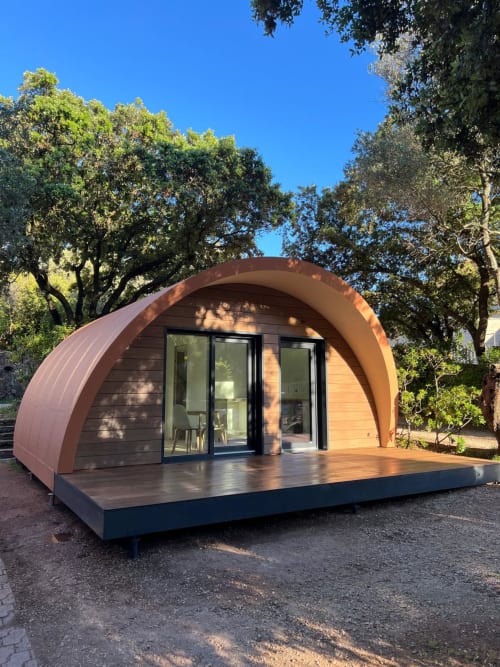 Pod de glamping en bois aux formes courbes du Camping La Lézardière à La Valette du Var, entouré de verdure