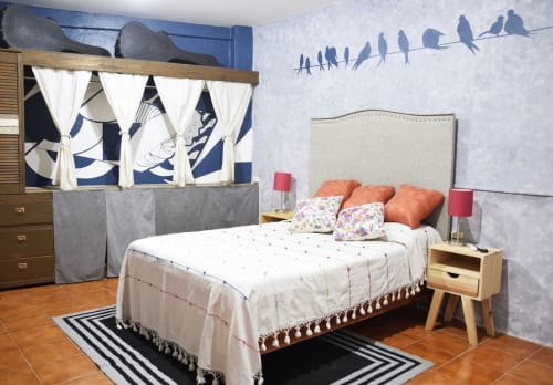 Dormitorio moderno de apartamento LLUNA en Oaxaca con arte mural de pájaros azules, cama acogedora y vistas al jardín