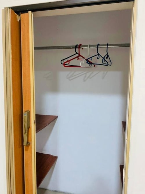 Armario vacío con repisas de madera y perchas coloridas en el hotel Casa Mango de Cali, Colombia