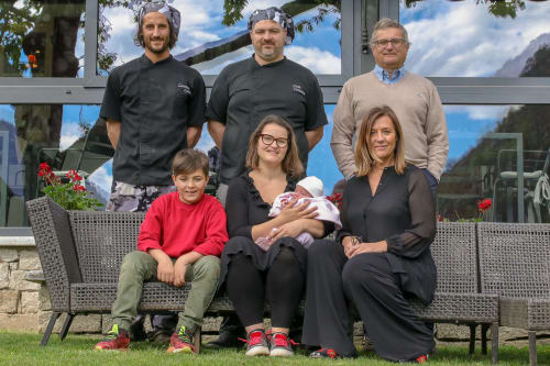 Famiglia in posa all'aperto presso la Locanda del Sasso Rooms a Crodo, Italia, con vista sulle montagne
