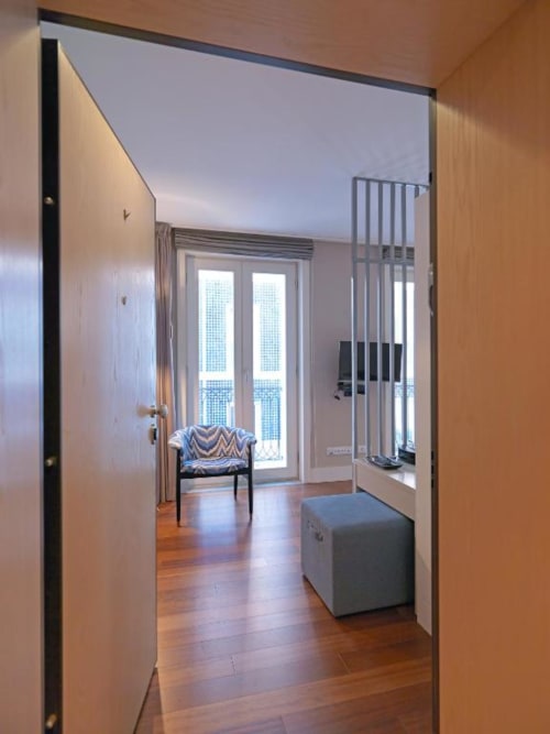 Studio apartment hallway at New Oporto Apartments in Porto with wooden floors, city view balcony, and modern furnishings
