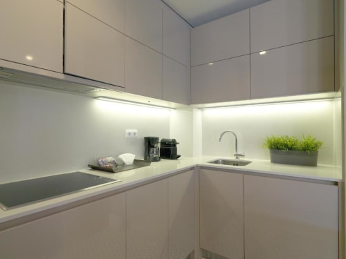 Modern kitchenette in Superior Apartment at New Oporto Apartments, Porto, with white cabinetry, under-cabinet lighting,