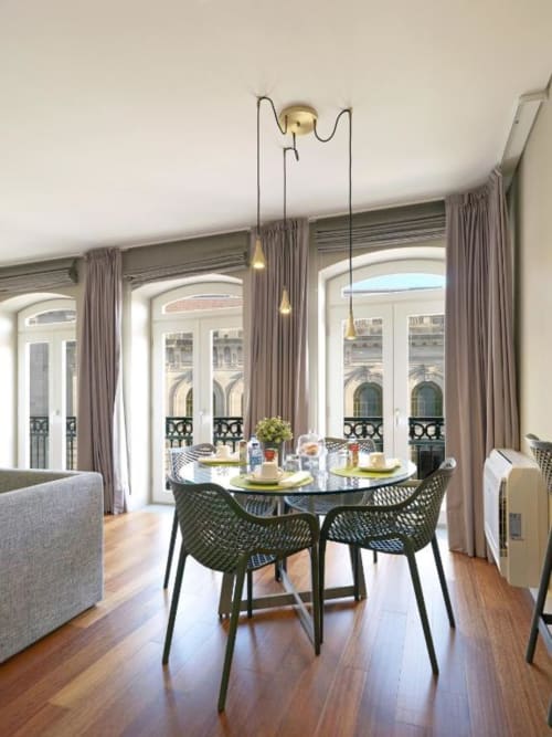 Superior Apartment dining area with round table, green chairs, and views of Porto's landmark architecture through French
