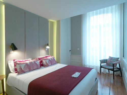 Quarto moderno no New Oporto Apartments no Porto com detalhes em borgonha, iluminação ambiente e janelas do piso ao teto