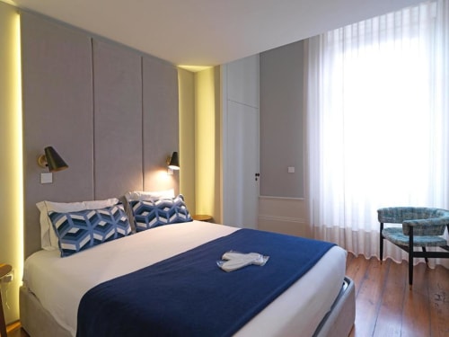 Superior Apartment bedroom at New Oporto Apartments in Porto, featuring modern design with blue accents, ambient lighting,