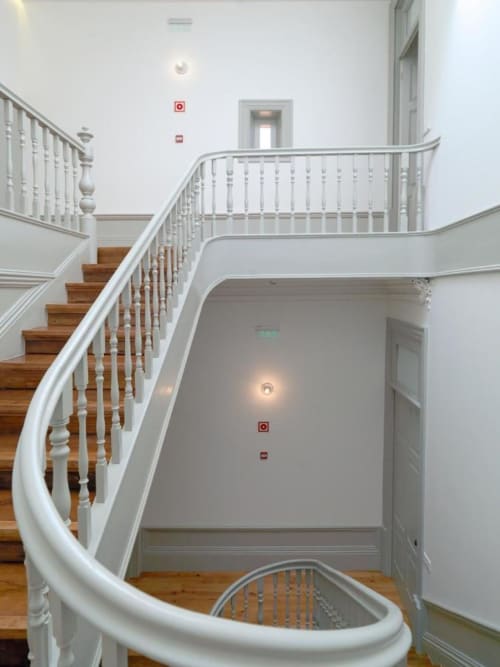Elegante escada curva com guarda-corpos brancos e degraus de madeira no New Oporto Apartments no Porto, Portugal