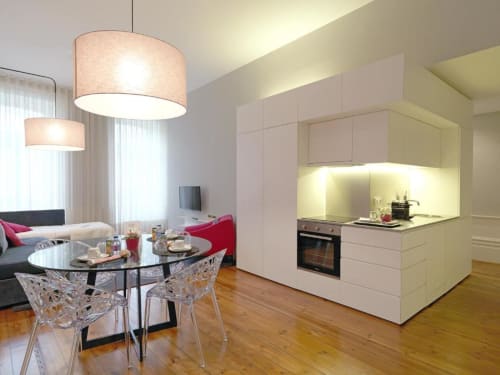 Modern deluxe apartment in Porto featuring open-plan kitchen with white cabinetry, dining area with glass table, and living