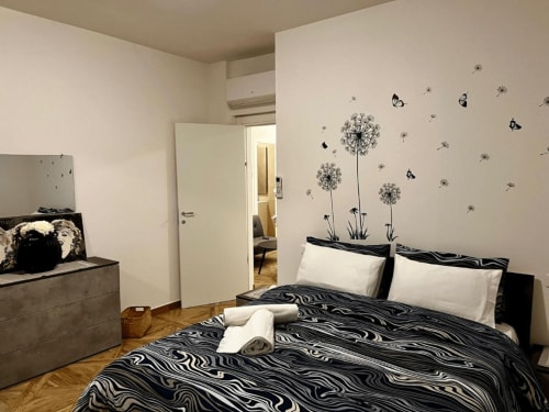 Modernes Schlafzimmer im EmilBo' House mit Zebra-Bettwäsche, Löwenzahn-Wandstickern und monochromen Möbeln
