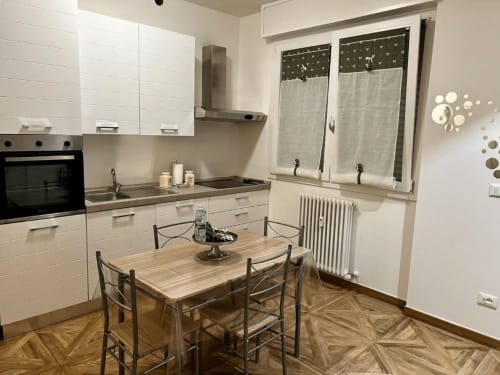 Moderne Küchen-Essbereich im EmilBo' House mit weißen Schränken, Holzesstisch und Fischgrätparkett in San Lazzaro