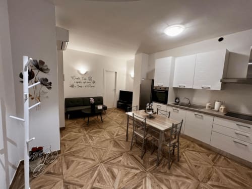 Moderne offene Küche und Wohnbereich in EmilBo' House mit weißen Möbeln, Esstisch und schwarzem Sofa in San Lazzaro