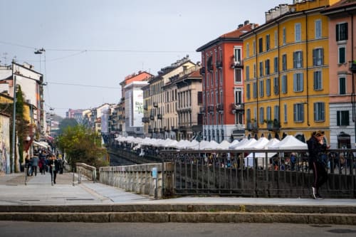 Colorful Milan street scene with historic buildings and outdoor market near YOUnique Boutique Rooms