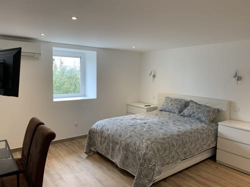 Chambre moderne au Gîte du Port à Saint Pierre de Boeuf avec lit queen-size, vue sur jardin et design contemporain