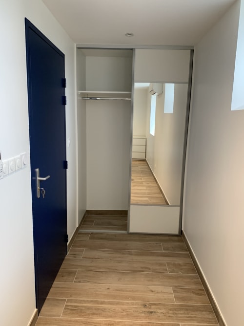 Entrée moderne de chambre au Restaurant du Port, Saint Pierre de Boeuf, avec porte bleu foncé et armoire miroir