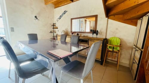 Salle à manger du gîte Conciergerie Pour Tous avec table, chaises et vue sur la cuisine à Darazac