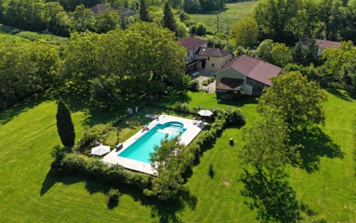 Vue aérienne de Les papillons de baccara à Gondrin, France avec une piscine turquoise entourée de jardins verdoyants