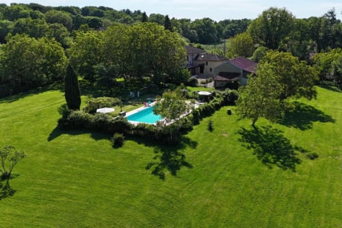 Vue aérienne de l'hôtel Les Papillons de Baccara à Gondrin avec piscine turquoise, jardins et campagne environnante.