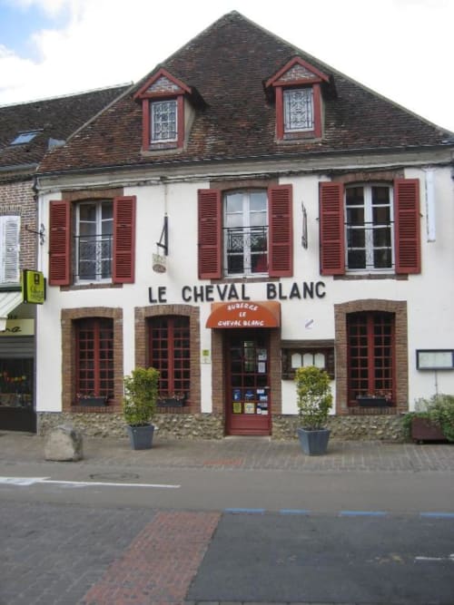 Le Cheval Blanc building with red shutters and mansard roof in Sépeaux Saint Romain, France