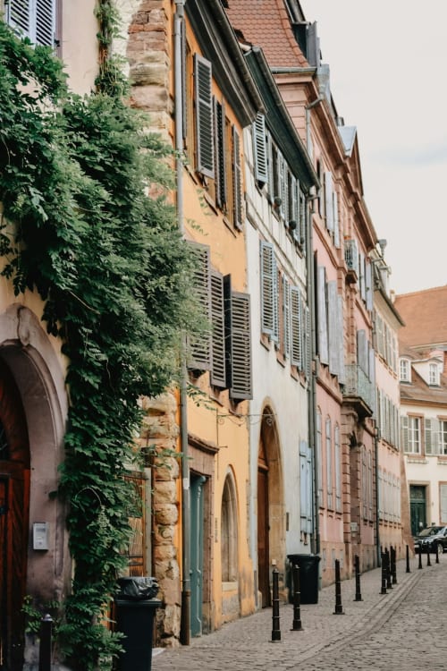 Rue historique de Gondrin en France avec bâtiments couverts de lierre et fenêtres volets