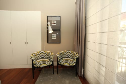 Modern apartment sitting area at New Oporto Apartments in Porto with patterned yellow armchairs, white closet, and city view