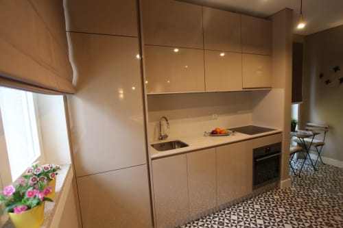 Modern kitchen in New Oporto Apartments Porto, with beige cabinets, sink, cooktop, and dining area