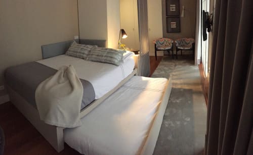 Modern bedroom at New Oporto Apartments in Porto with queen bed, desk lamp, and seating area