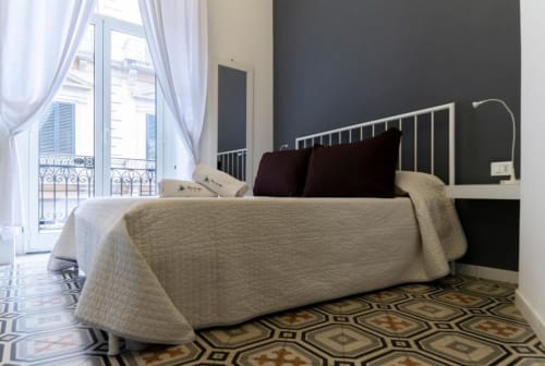 Camera matrimoniale deluxe a C'era una Volta a Palermo con struttura letto in metallo, biancheria beige, parete accent scura e stile parigino