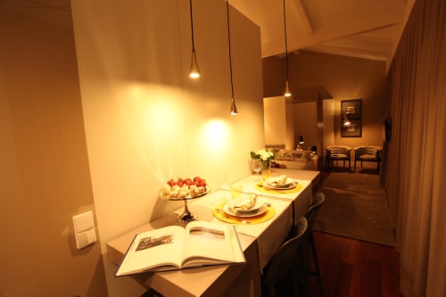 Elegant dining area in New Oporto Apartments Porto with set table, fresh flowers, pendant lights, and open kitchen view