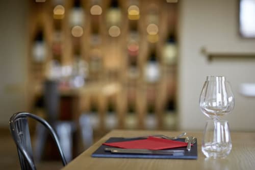 Elegant table setting at Les Maisons de Chamirey with wine glass, napkins, and chair in Mercurey