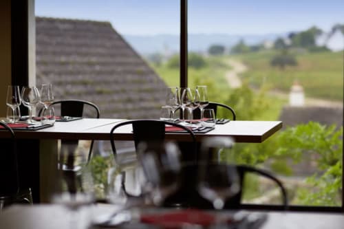 Elegant dining table with wine glasses overlooking rolling vineyards at Les Maisons de Chamirey, Mercurey