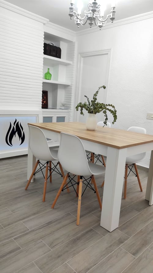 Comedor moderno en Casa Torrens con mesa de madera, sillas blancas y estantes integrados
