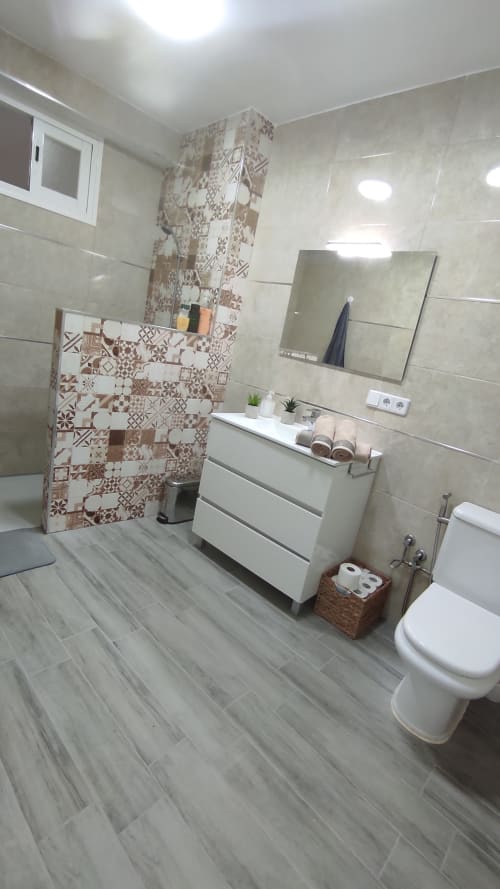 Baño moderno en Casa Torrens Mar y Montaña en Polop de la Marina con ducha de azulejos decorativos, lavamanos blanco y gris