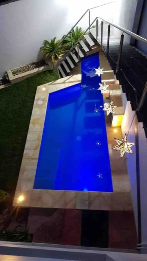 Piscina privada iluminada en azul de la villa Zoogocho Boutique House en San Andrés Huayapam, México