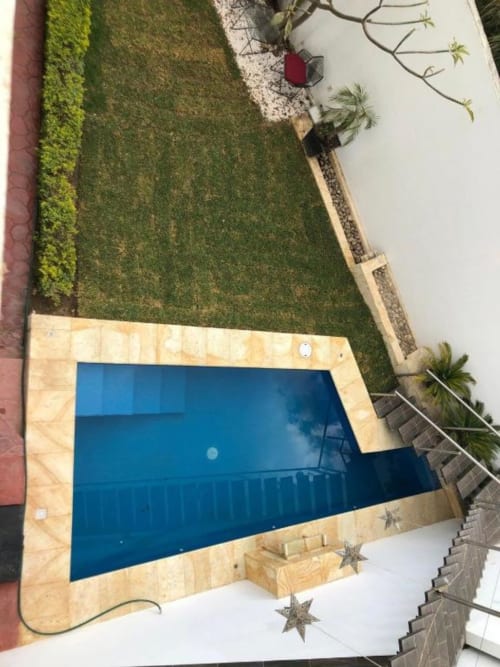 Vista aérea de la piscina privada de la villa Zoogocho Boutique rodeada de jardín manicurado y patio de piedra en San Andrés