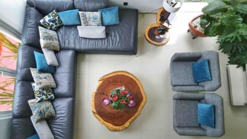 Vista cenital de la sala de estar moderna con sofá seccional, mesa de madera natural, plantas en maceta y detalles en azul vibrante