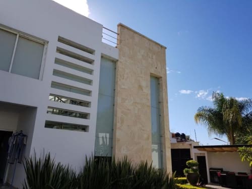 Villa moderna de piedra y blanco en Zoogocho Boutique House, San Andrés Huayapam, con diseño de ventanales horizontales y ambiente tropical