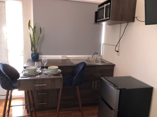 Zona de cocina-comedor moderna en Apartamento Zeus 12 de Alojamientos Zoogocho con muebles de madera oscura, mesa para dos y